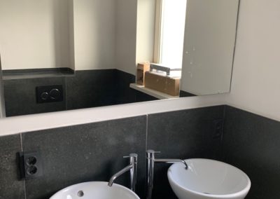 Badkamer zwart met wastafelmeubel en waskommen
